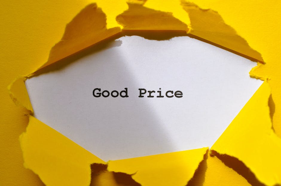 A white card with the words 'Good Price' printed in black, seen through a torn yellow paper background. The torn edges of the yellow paper frame the card, creating a contrast between the bright yellow